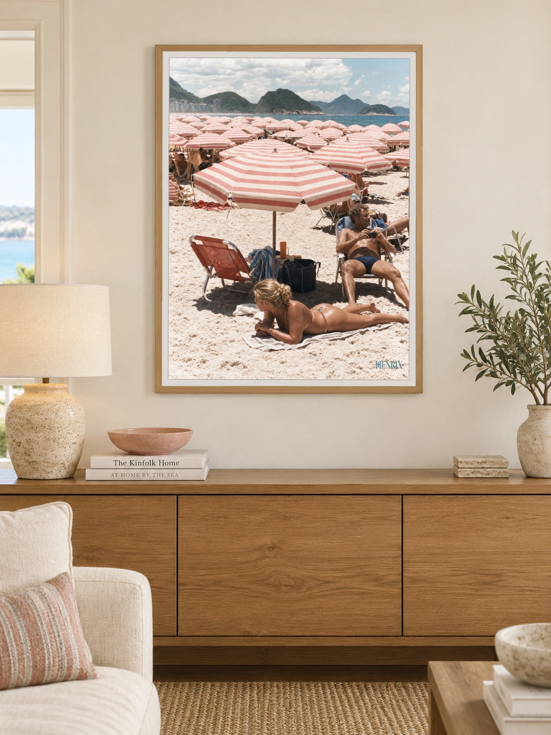 Copacabana Dreaming print, 30 × 40 inch, Natural Wood frame above a wood sideboard in a waterfront living room
