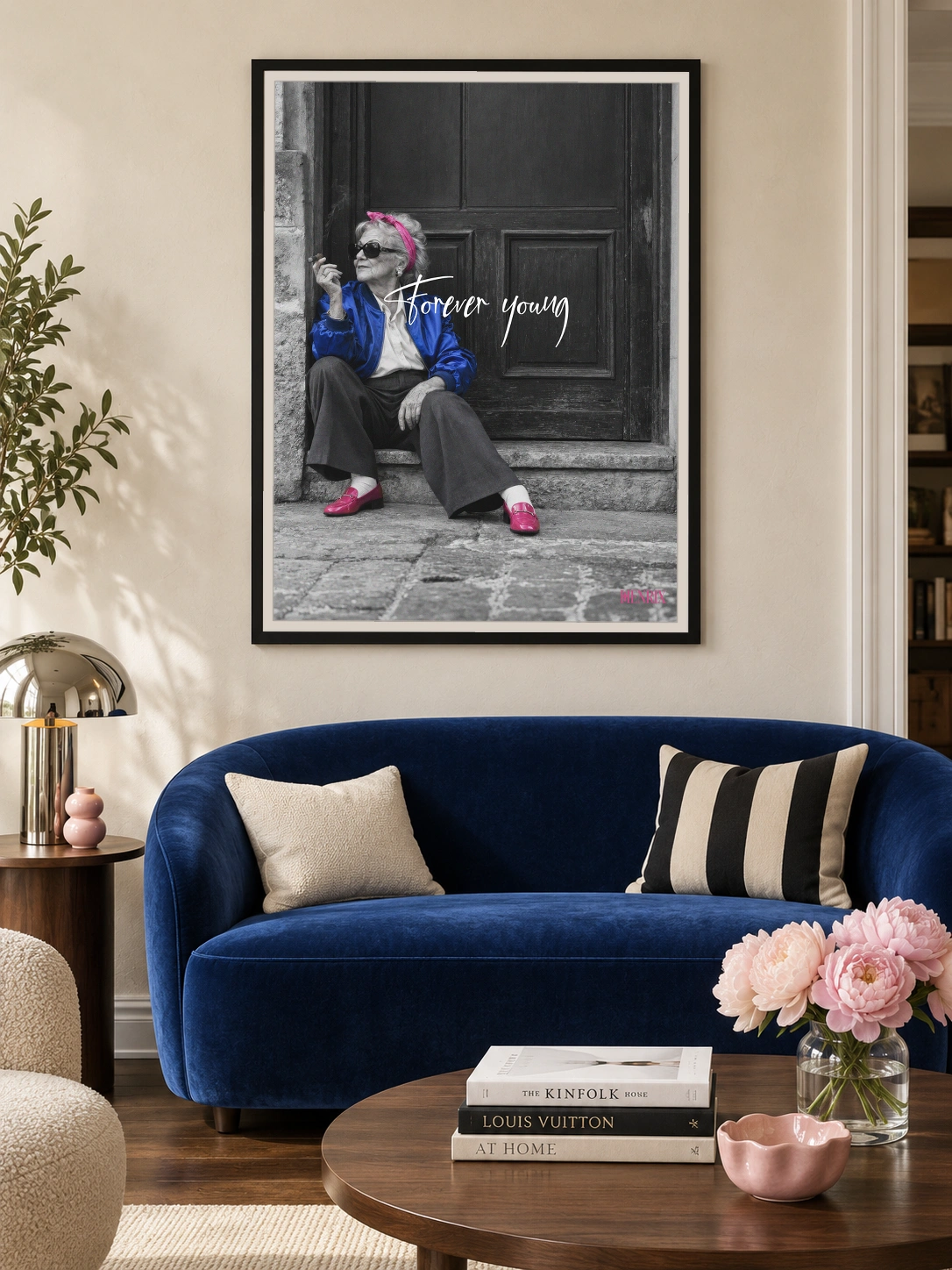 Forever Young print, 30 × 40 inch, black frame above a curved cobalt-blue sofa