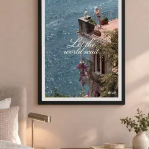 Let the World Wait print, 18 × 24 inch, black frame on a bedroom wall beside a brass lamp