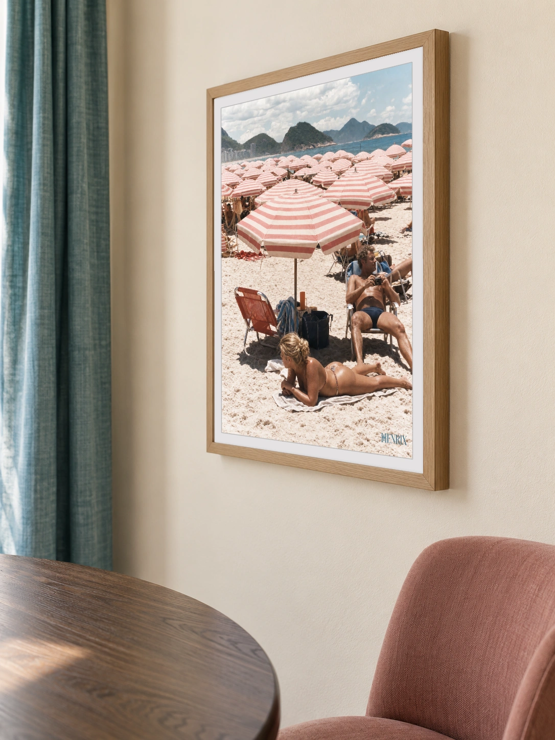 Copacabana Dreaming print, 18 × 24 inch, Natural Wood frame above a dining table near teal curtains, viewed obliquely