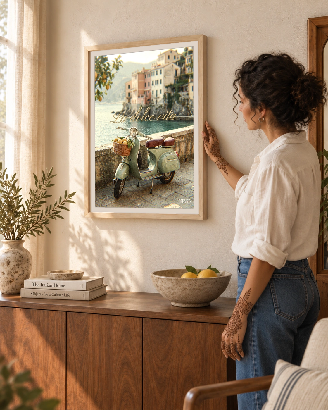 La Dolce Vita print, 18 × 24 inch, Natural Wood frame beside a woman in a white shirt and jeans touching the frame