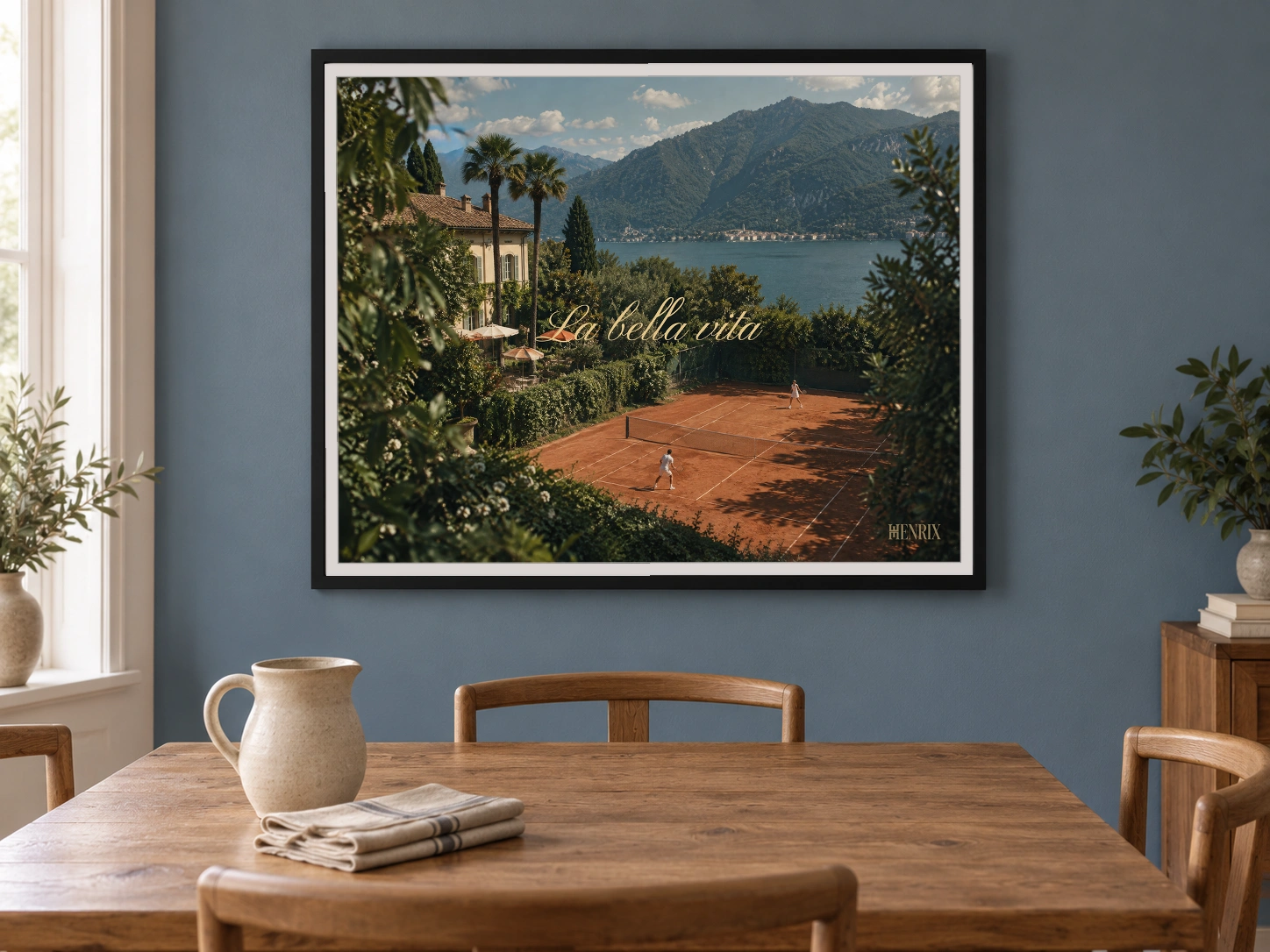 La Bella Vita print, 40 × 30 inch, black frame above a round dining table on a blue wall