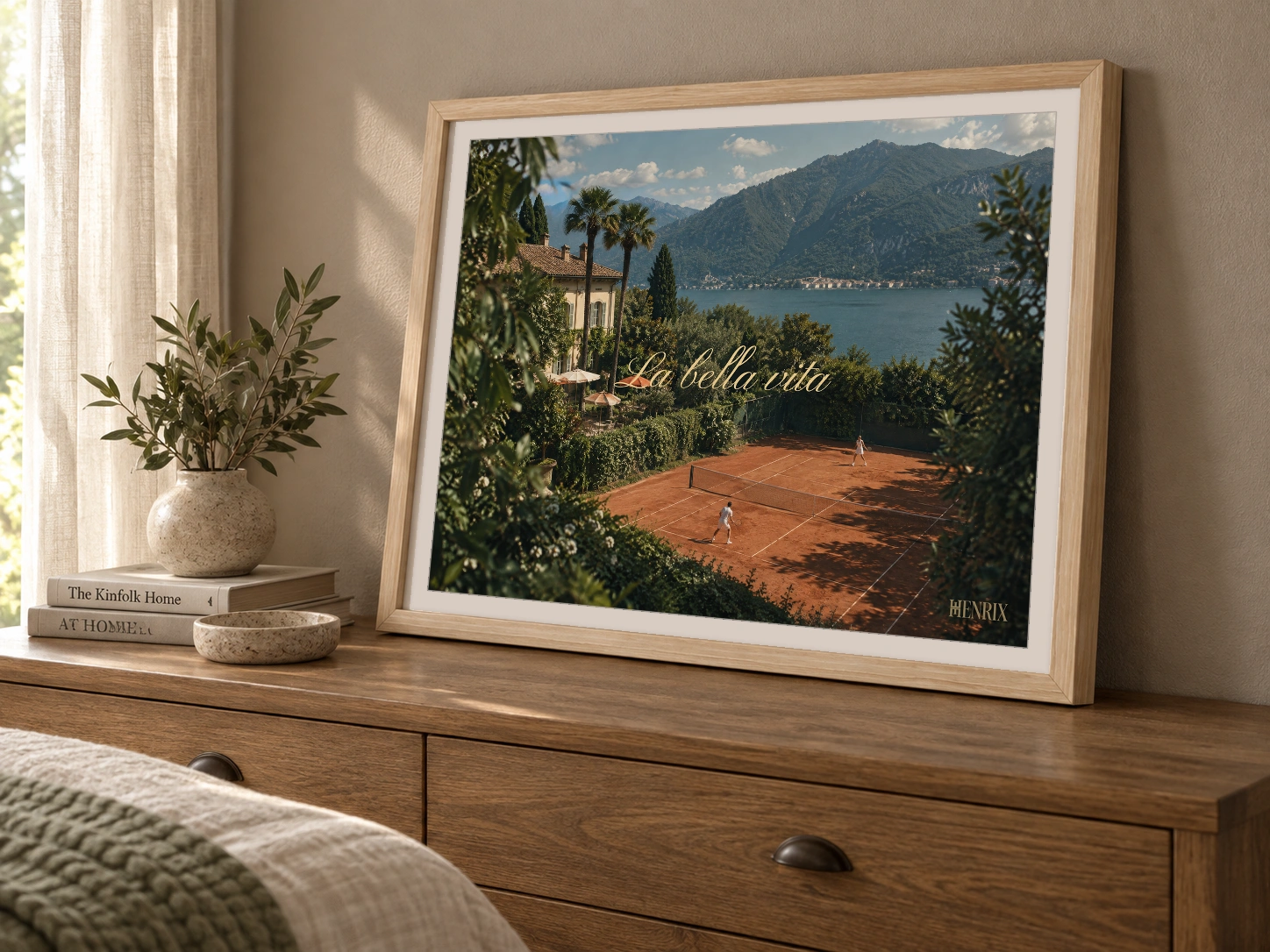 La Bella Vita print, 24 × 18 inch, Natural Wood frame leaning on a wood chest of drawers, viewed from the side