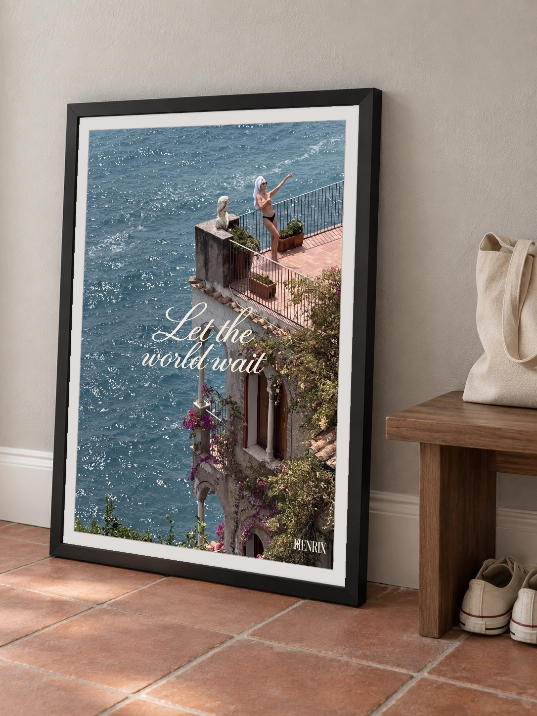 Let the World Wait print, 18 × 24 inch, black frame leaning on a terracotta-tiled hallway floor