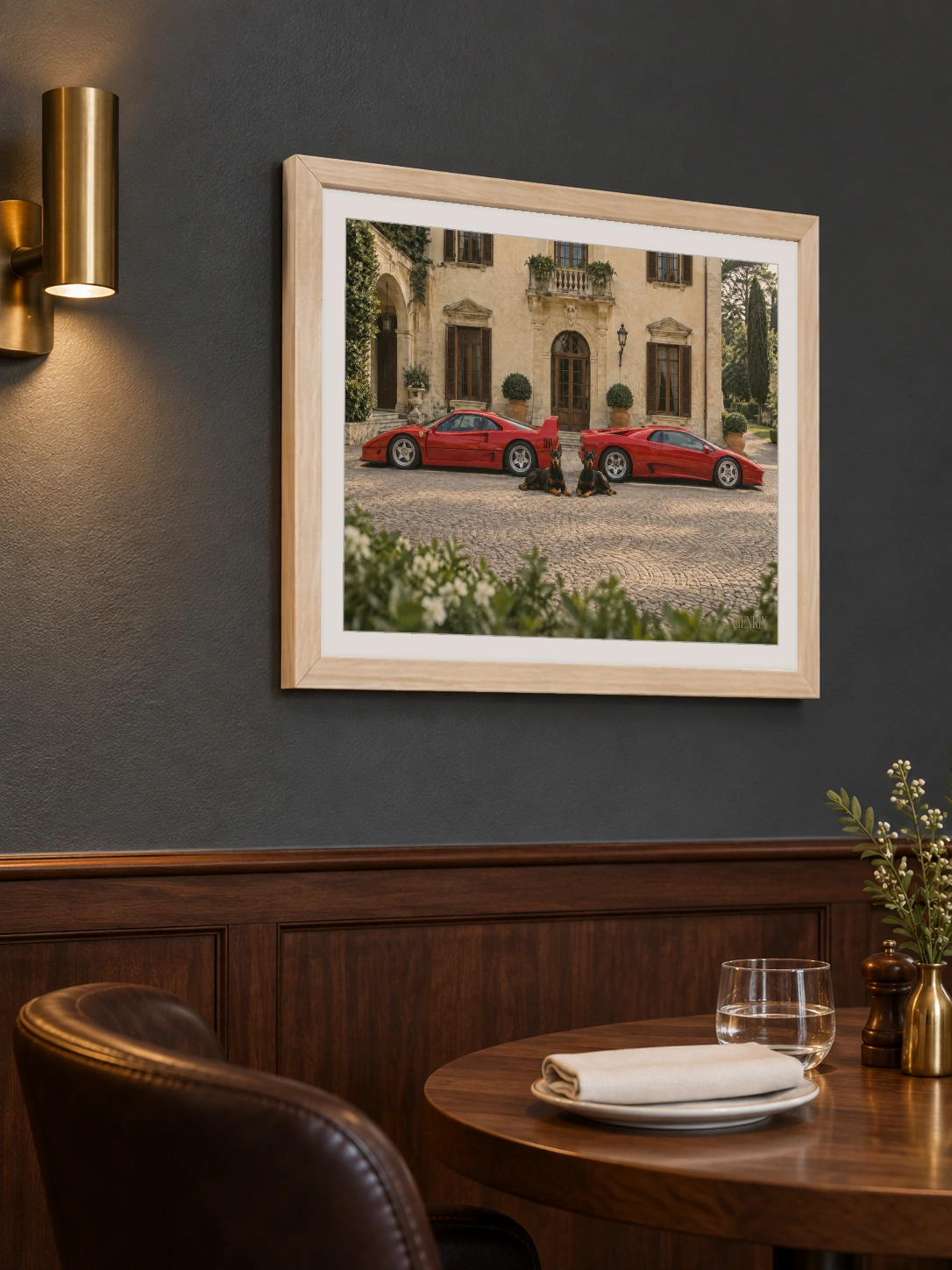 The Watchdogs print, 16 × 12 inch, Natural Wood frame above a restaurant table on a blue wall, viewed from the side