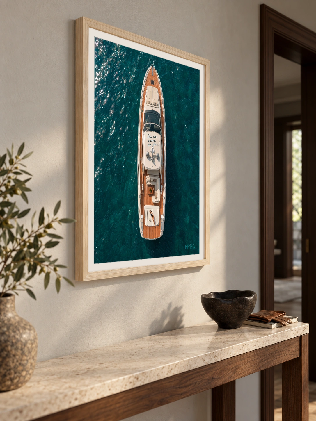 This Was Always the Plan print, 18 × 24 inch, Natural Wood frame above a stone entry console, viewed at an angle