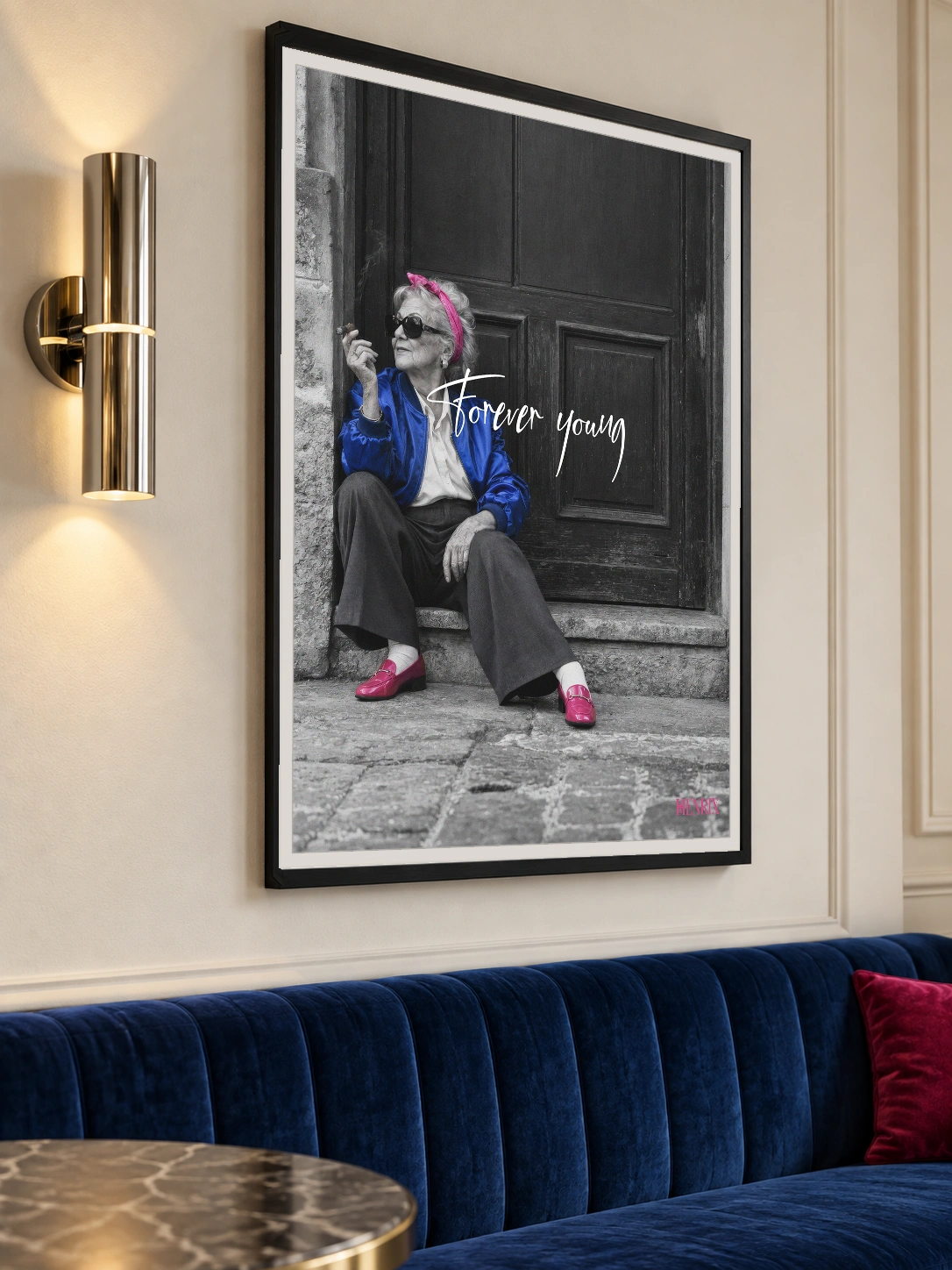 Forever Young print, 30 × 40 inch, black frame above a blue restaurant banquette, viewed at an angle