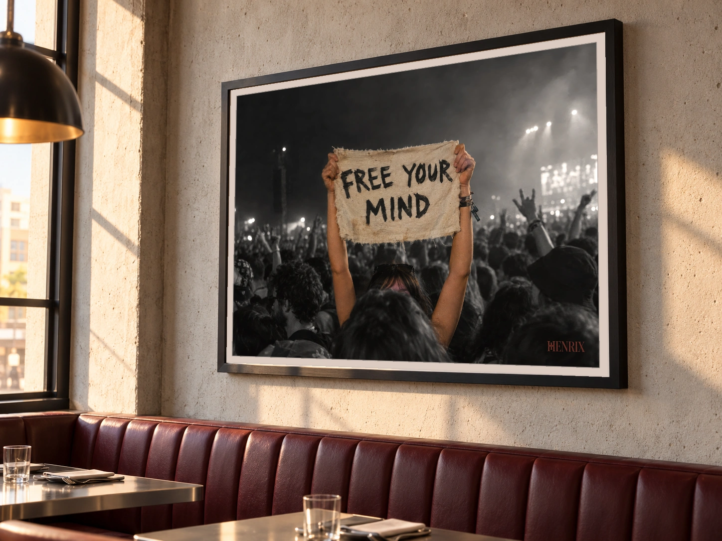 Free Your Mind print, 40 × 30 inch, black frame above a burgundy restaurant banquette, viewed at an angle