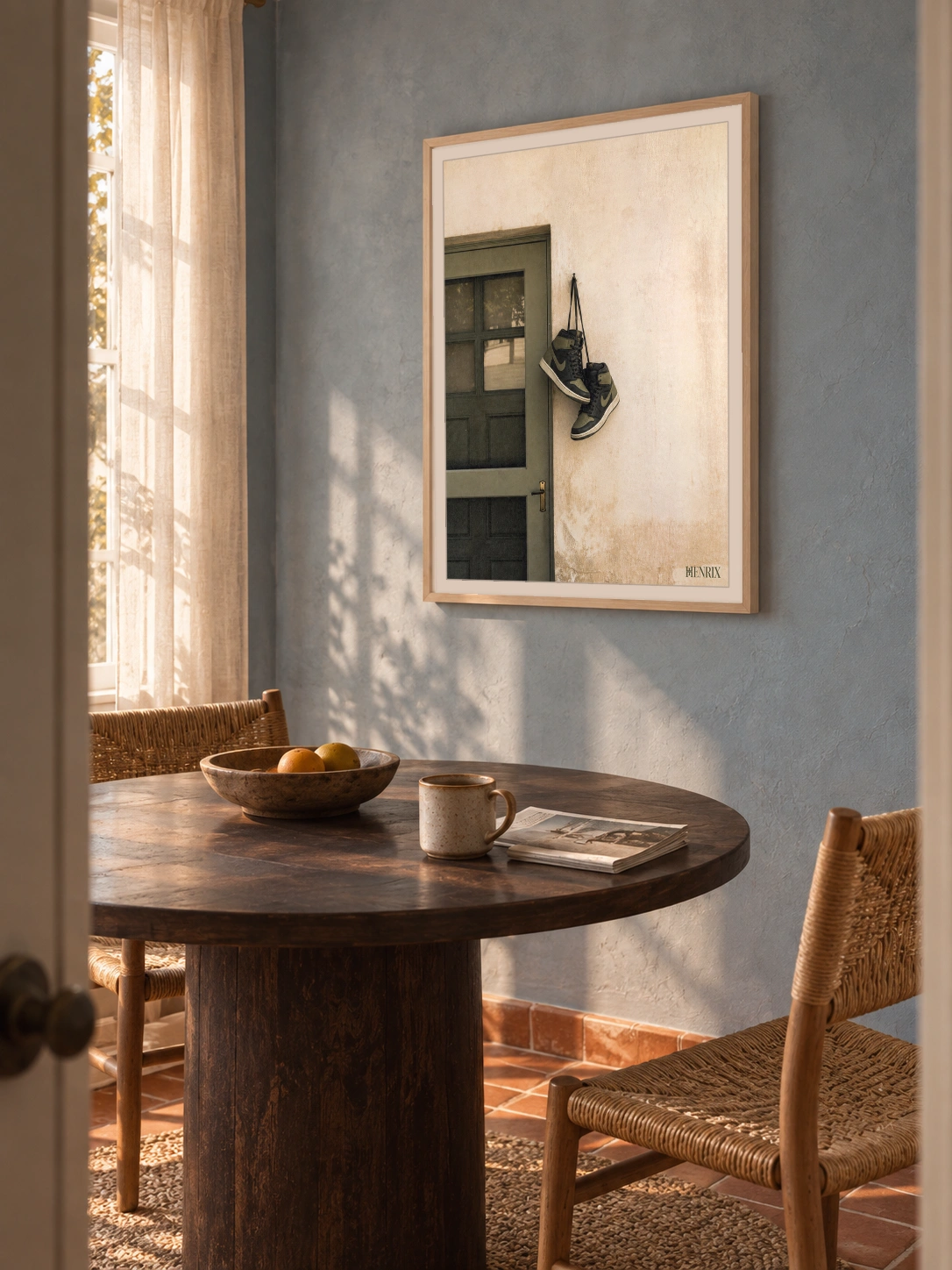 Home at Last print, 18 × 24 inch, Natural Wood frame above a dining table on a blue wall, viewed obliquely