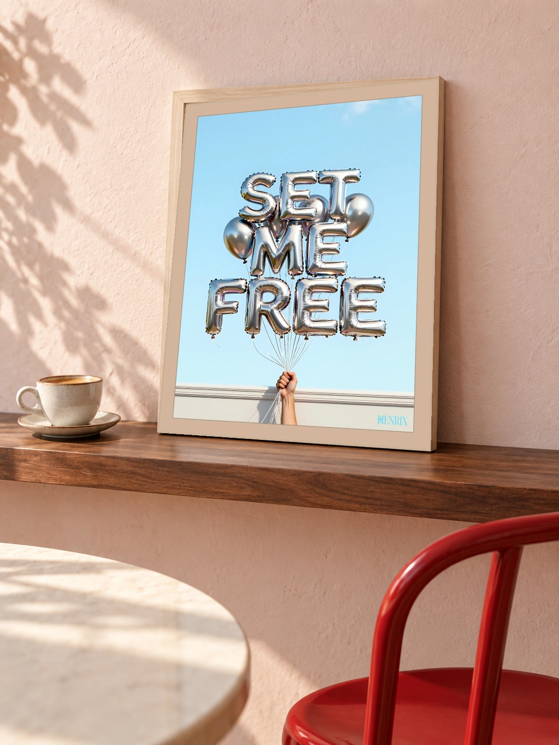 Set Me Free print, 12 × 16 inch, small Natural Wood frame leaning on a wood ledge near a red chair